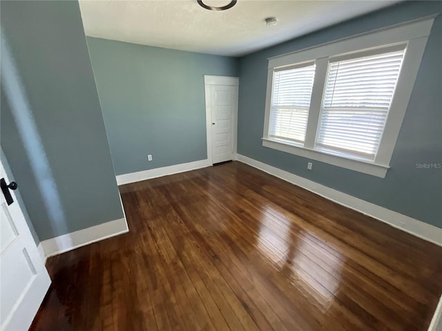 unfurnished room featuring dark wood-type flooring