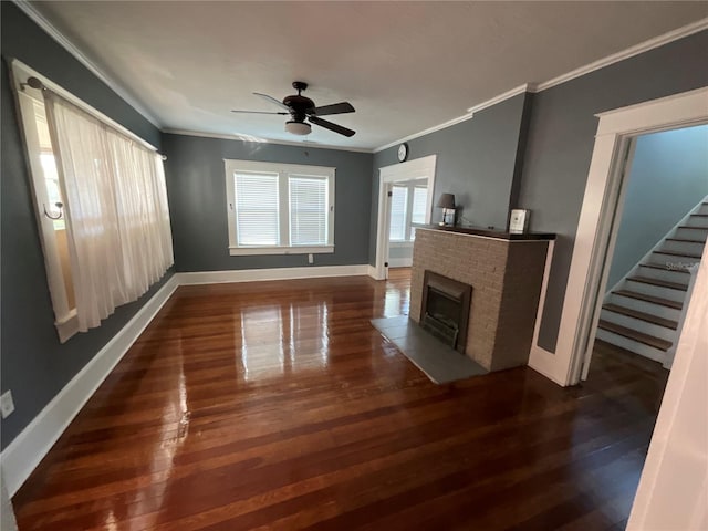 unfurnished living room with crown molding, a brick fireplace, ceiling fan, and dark hardwood / wood-style floors