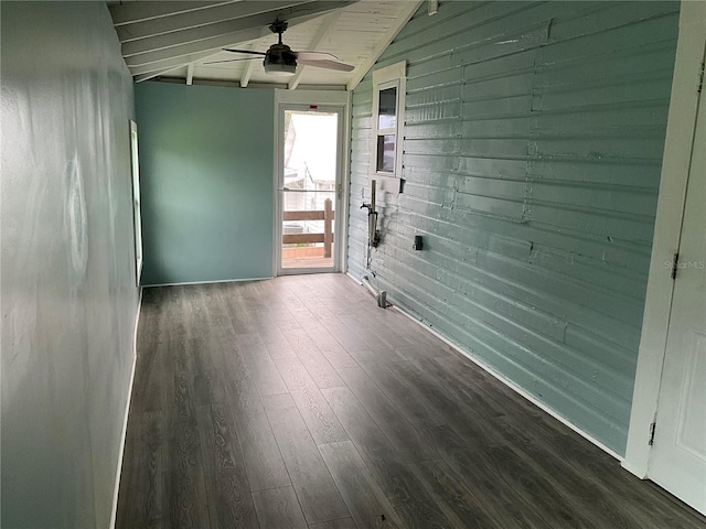 spare room with wood walls, ceiling fan, dark hardwood / wood-style floors, and lofted ceiling with beams