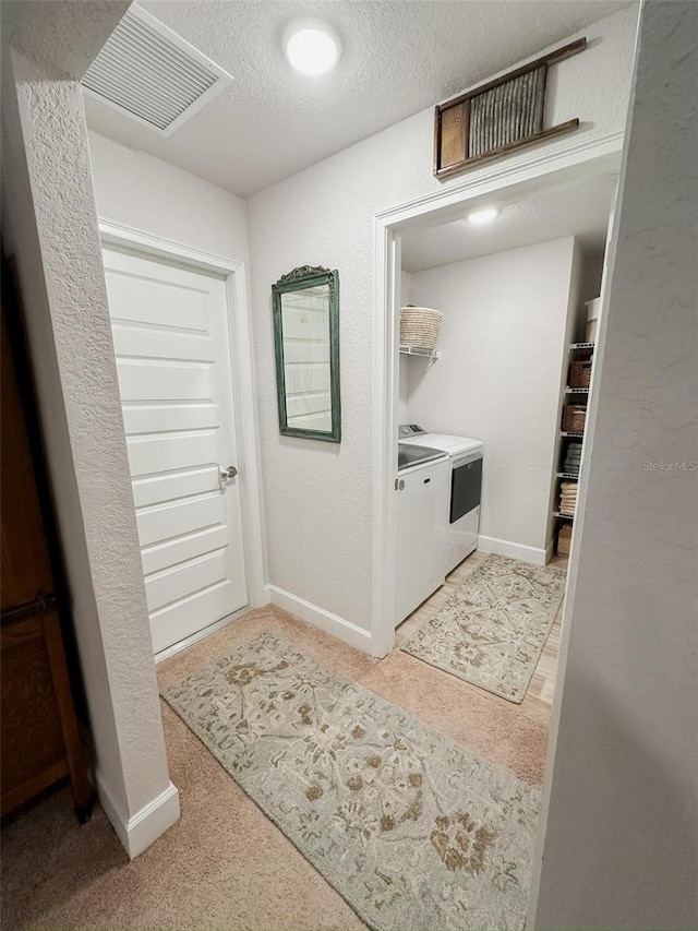 laundry area with washer and dryer and a textured ceiling