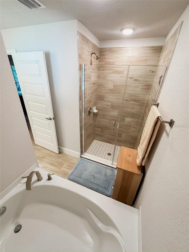 bathroom featuring walk in shower, wood-type flooring, sink, and a textured ceiling