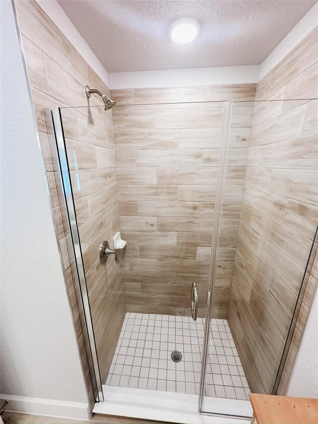 bathroom featuring a textured ceiling and walk in shower