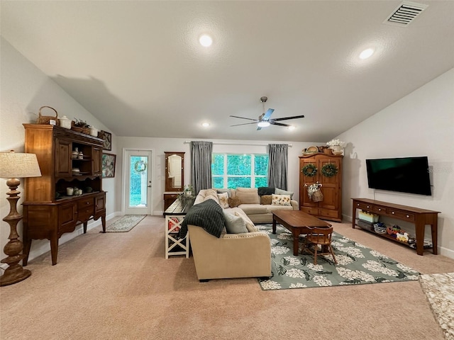 carpeted living room with ceiling fan and vaulted ceiling