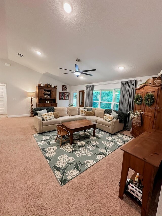 living room featuring ceiling fan, carpet flooring, vaulted ceiling, and a textured ceiling