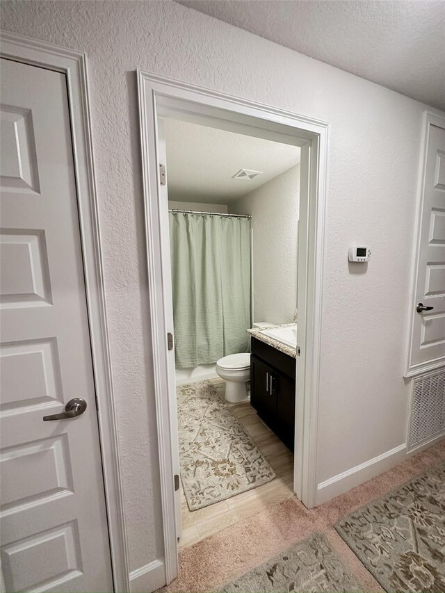 bathroom with vanity, a textured ceiling, toilet, and a shower with shower curtain