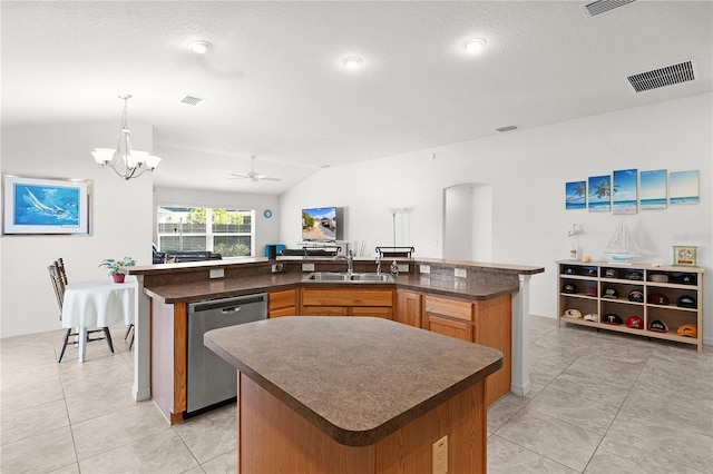 kitchen featuring light tile patterned floors, vaulted ceiling, dishwasher, and a kitchen island with sink