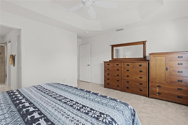 bedroom featuring ceiling fan, light tile patterned flooring, and a tray ceiling