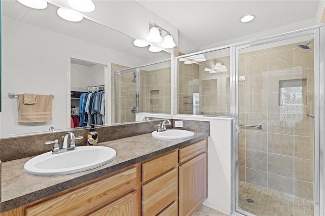 bathroom with dual bowl vanity and a shower with shower door