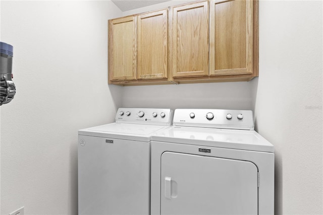 laundry room featuring cabinets and washer and clothes dryer