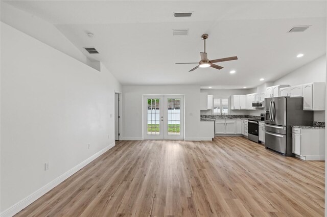 kitchen with appliances with stainless steel finishes, white cabinets, lofted ceiling, ceiling fan, and light hardwood / wood-style flooring