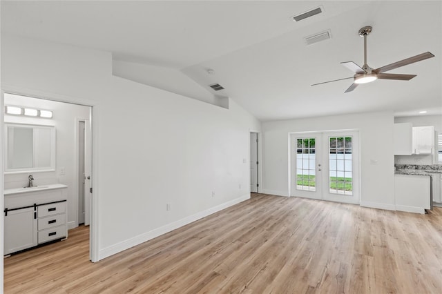 unfurnished living room with sink, ceiling fan, light hardwood / wood-style flooring, lofted ceiling, and french doors