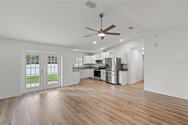 kitchen featuring french doors, light hardwood / wood-style floors, lofted ceiling, white cabinetry, and appliances with stainless steel finishes