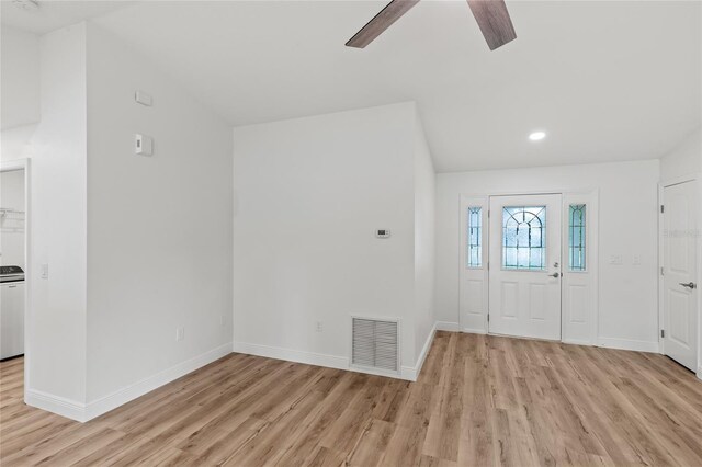 entrance foyer featuring light hardwood / wood-style flooring, washer / clothes dryer, ceiling fan, and vaulted ceiling