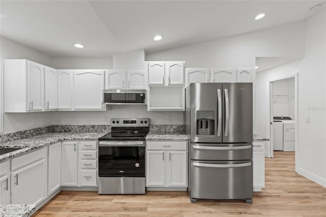 kitchen with stainless steel appliances, white cabinets, and vaulted ceiling