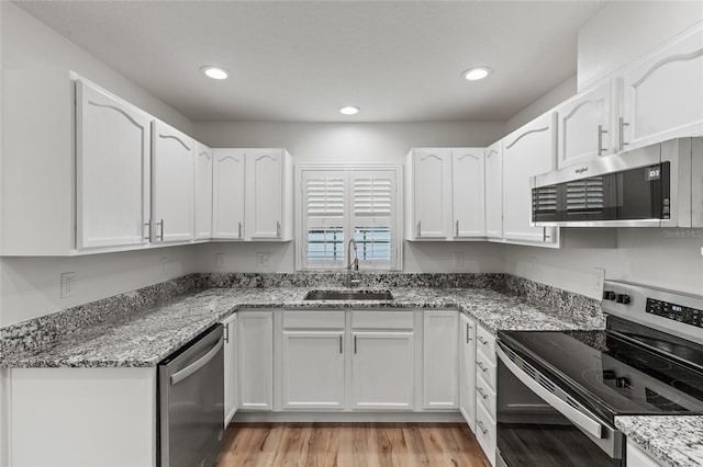 kitchen featuring sink, appliances with stainless steel finishes, stone countertops, and white cabinets