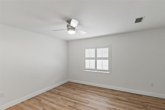 spare room featuring a textured ceiling, light hardwood / wood-style floors, and ceiling fan