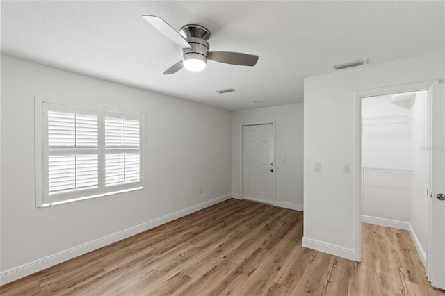 unfurnished bedroom with light hardwood / wood-style flooring, ceiling fan, and a closet