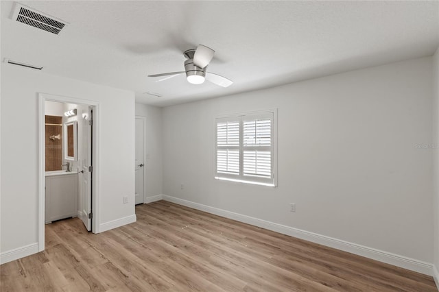 unfurnished bedroom featuring ensuite bath, sink, ceiling fan, and light hardwood / wood-style flooring