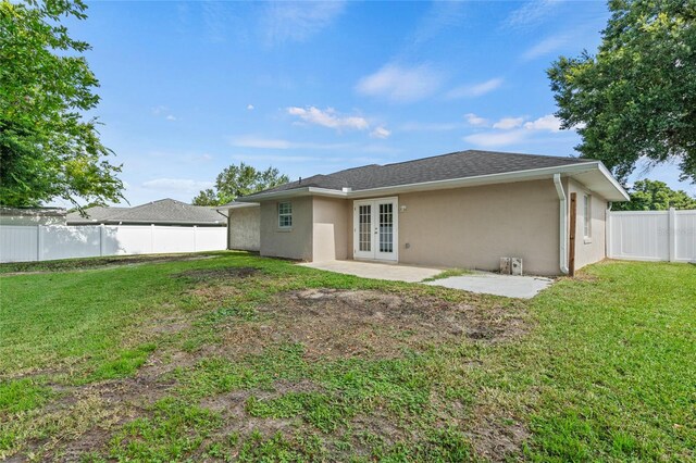 back of house with french doors, a lawn, and a patio