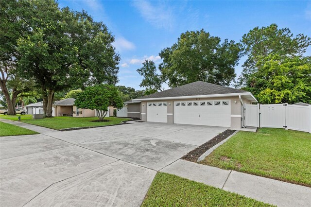 single story home featuring a garage and a front yard