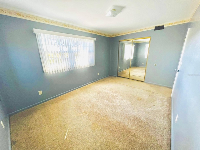 unfurnished bedroom featuring carpet flooring and a closet