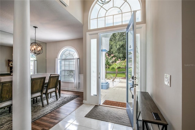 entryway with a high ceiling, light wood-type flooring, and a chandelier