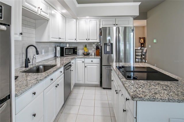 kitchen featuring stainless steel appliances, sink, backsplash, light tile patterned flooring, and white cabinetry