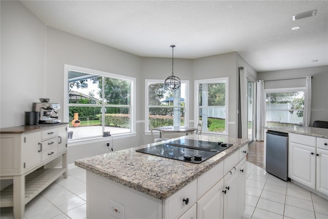 kitchen with light tile patterned flooring, black electric cooktop, white cabinets, and a wealth of natural light