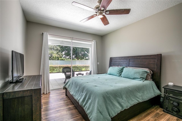 bedroom featuring hardwood / wood-style flooring, ceiling fan, access to exterior, and a textured ceiling