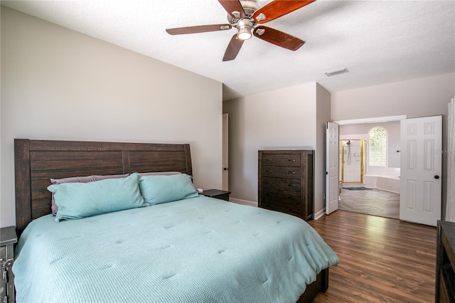 bedroom with ceiling fan, lofted ceiling, a textured ceiling, and dark hardwood / wood-style flooring