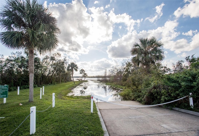 view of community with a water view and a lawn