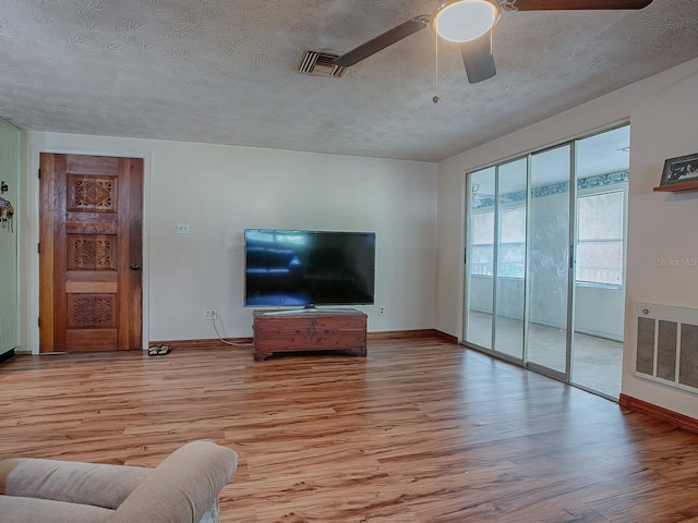 unfurnished living room with light hardwood / wood-style flooring, a textured ceiling, and ceiling fan