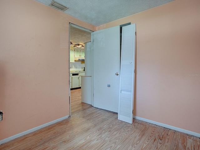 unfurnished bedroom featuring light hardwood / wood-style floors and a textured ceiling