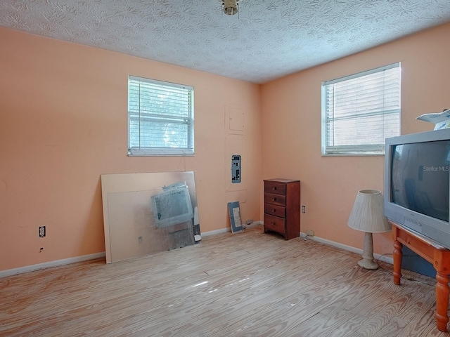 misc room featuring light hardwood / wood-style floors and a textured ceiling