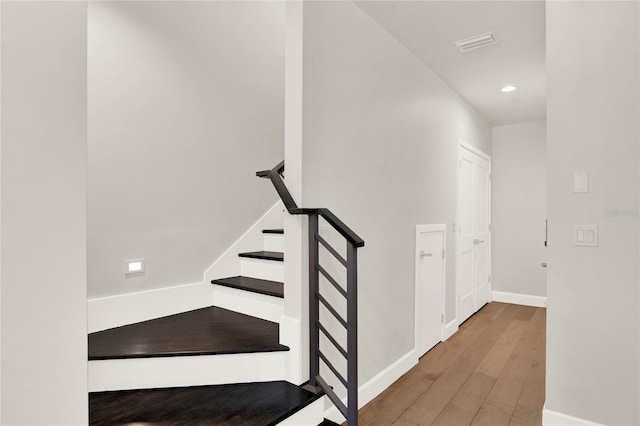 staircase with hardwood / wood-style floors