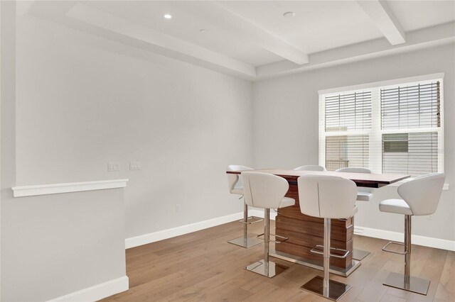 dining area with beamed ceiling and hardwood / wood-style floors