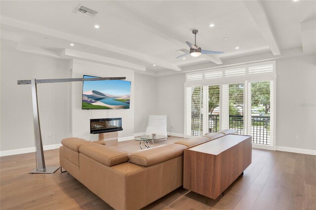 living room with beamed ceiling, ceiling fan, and wood-type flooring