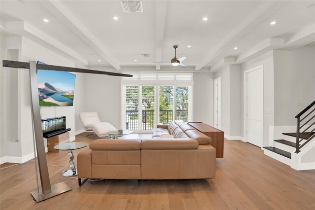 living room with beam ceiling, light hardwood / wood-style flooring, and ceiling fan