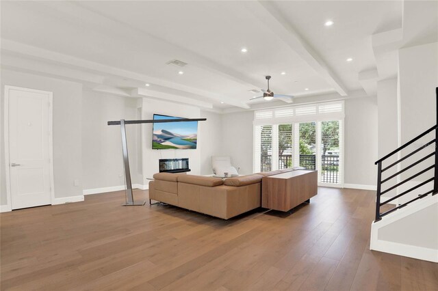 living room with wood-type flooring, beam ceiling, and ceiling fan