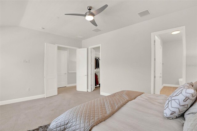 carpeted bedroom featuring ceiling fan, ensuite bathroom, a closet, and a spacious closet