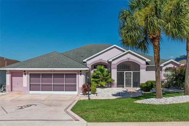 ranch-style home with a garage and a front lawn