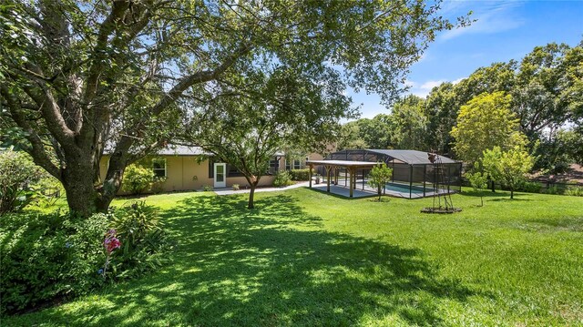 view of yard with a pool and a lanai