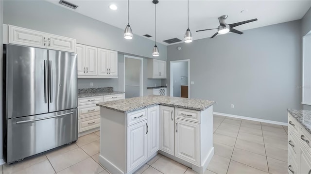 kitchen featuring stainless steel refrigerator, light stone countertops, and light tile patterned flooring