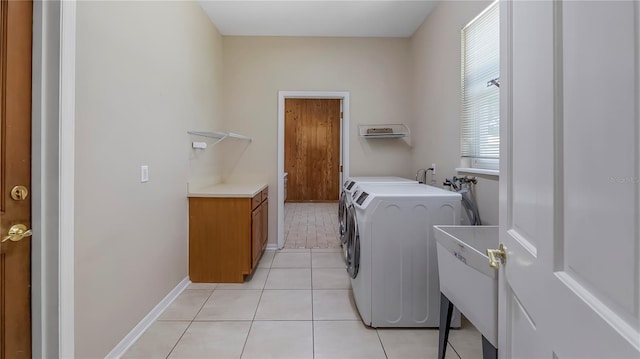 laundry area featuring washer and dryer, sink, and light tile patterned floors