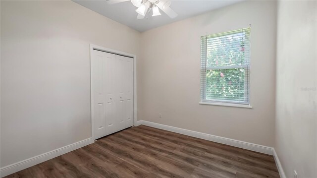 unfurnished bedroom featuring wood-type flooring, a closet, and ceiling fan