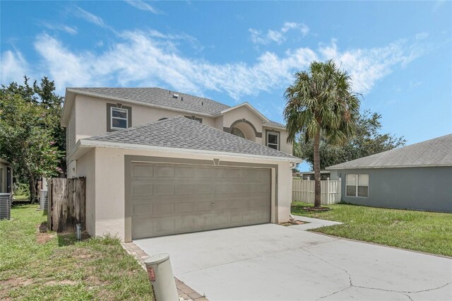 view of property featuring a garage and a front yard