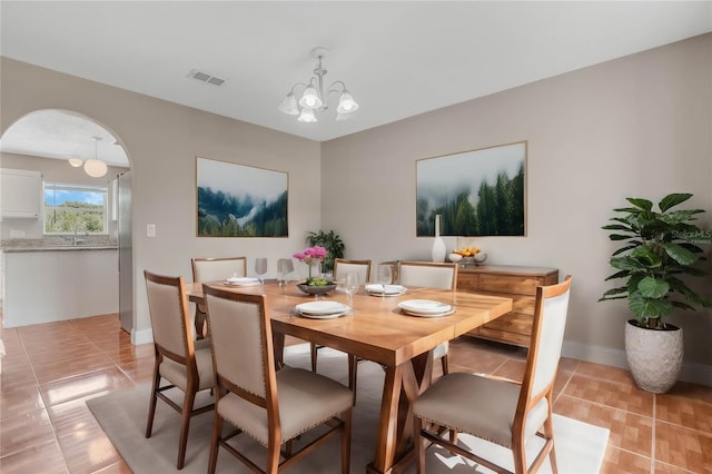 dining room featuring an inviting chandelier and light tile patterned flooring