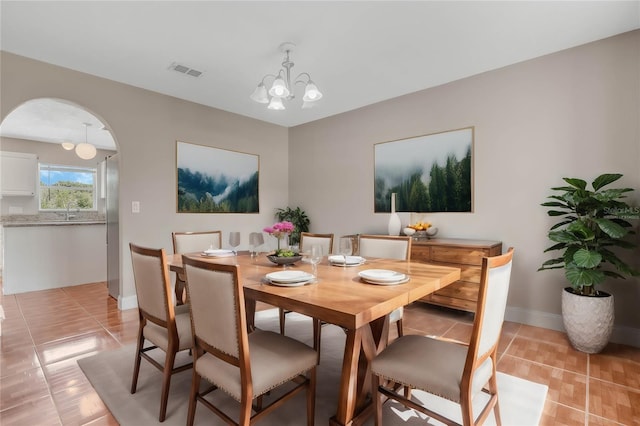 tiled dining room featuring a notable chandelier