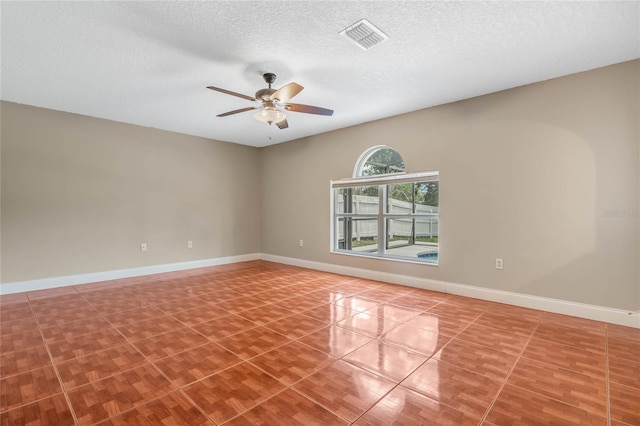 tiled empty room with a textured ceiling and ceiling fan