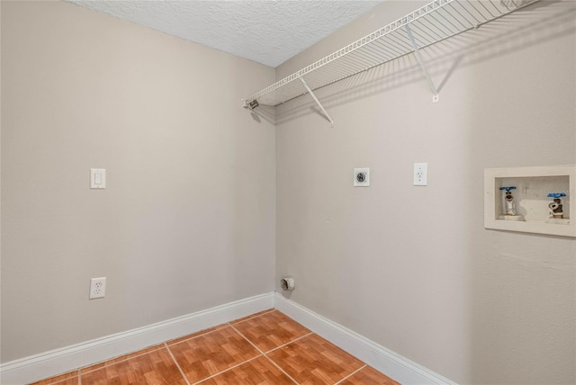 clothes washing area with hardwood / wood-style flooring, hookup for a washing machine, a textured ceiling, and electric dryer hookup